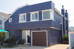 Blue two-story house with white trim and a brown garage door.