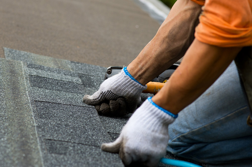 roofer putting shingles on roof